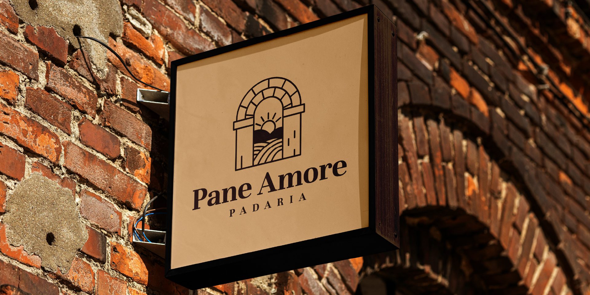 A imagem faz parte do projeto de Identidade Visual da Padaria Pane Amore e mostra uma placa na frente da loja
